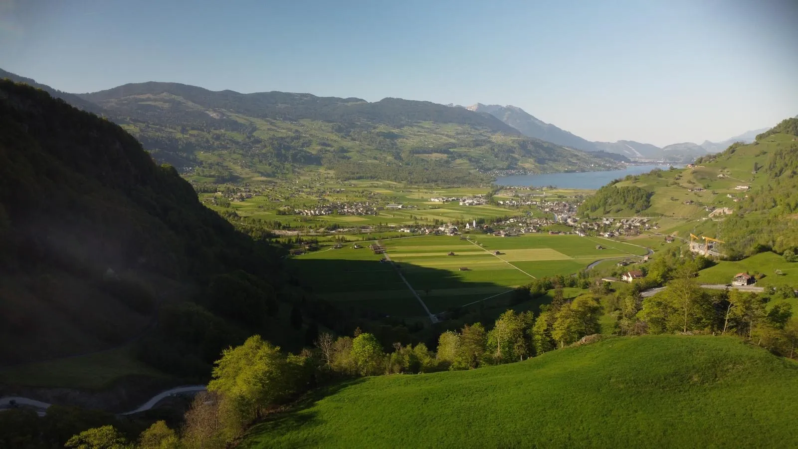 Grünes Tal mit Dörfern und See im Abendlicht