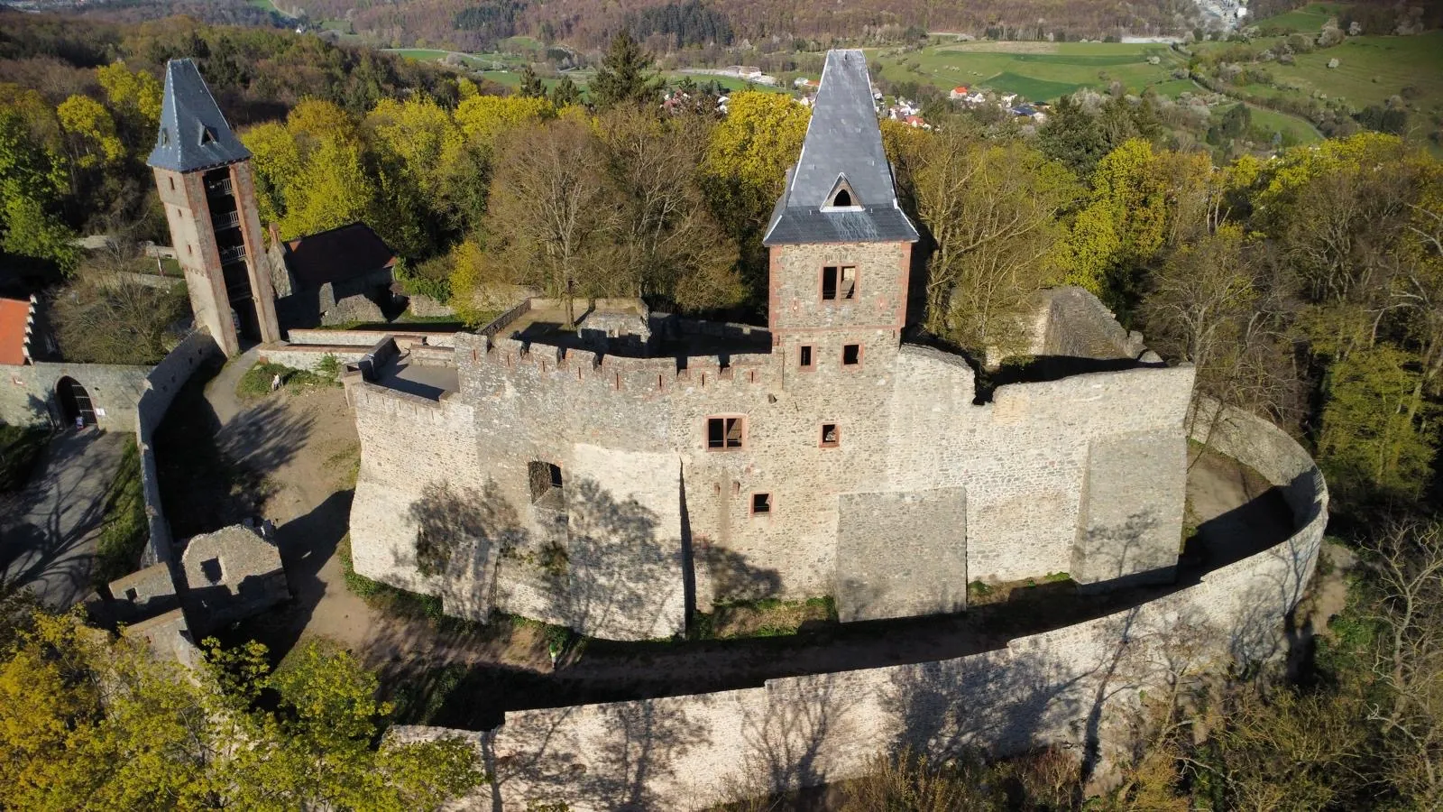 Burganlage mit zwei Türmen aus der Luft im Frühling