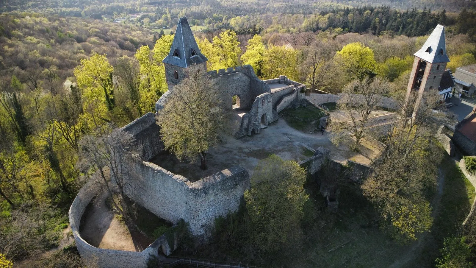 Burghof und Mauern einer Burgruine aus der Luft