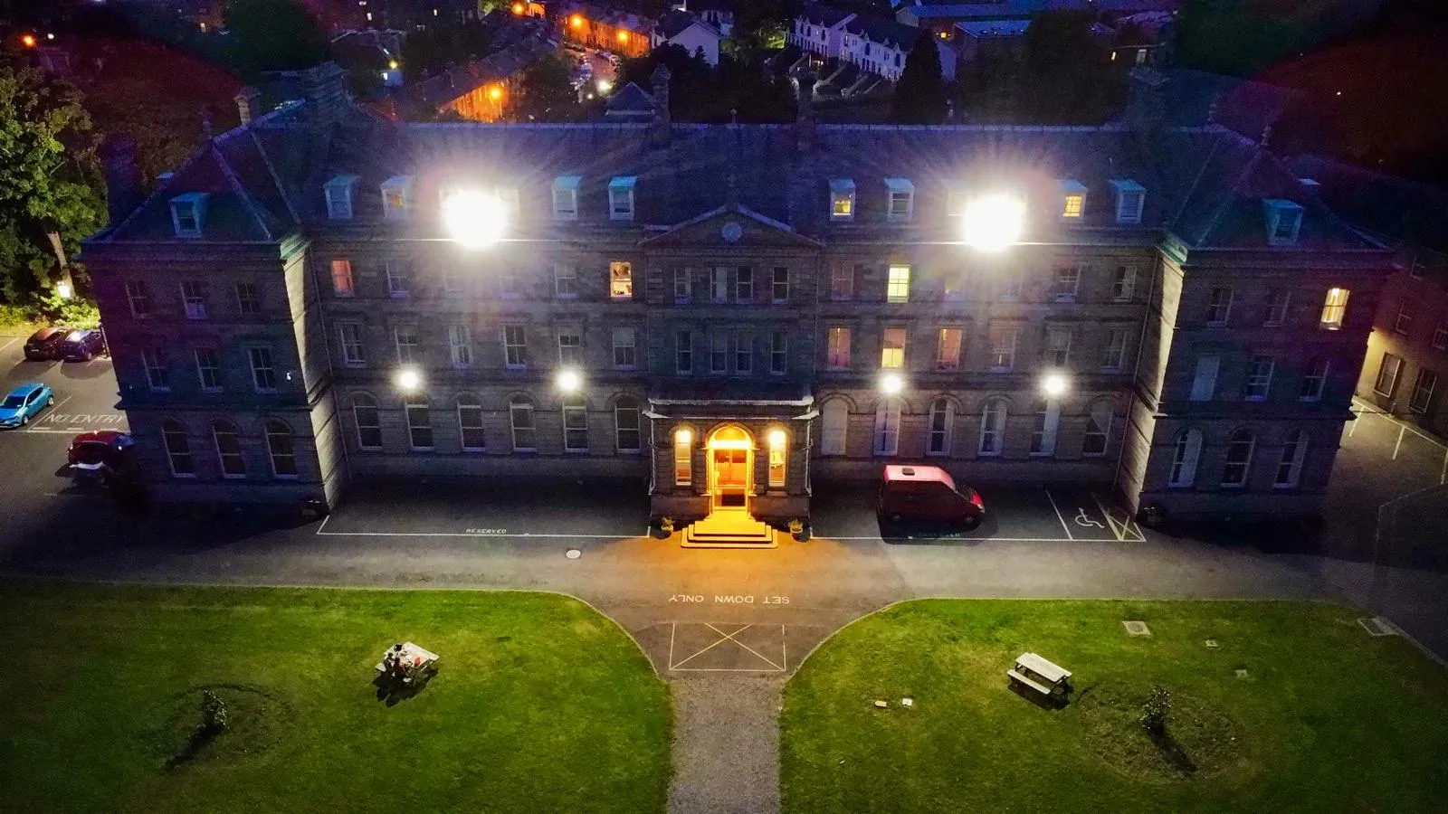 Historisches Universitätsgebäude in Irland bei Nacht aus der Luft